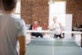 Man and woman in office space playing ping pong Royalty Free Stock Photo