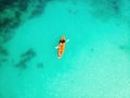 Man and Woman in an orange canoe in tropical waters. Top view from a drone