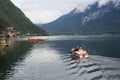 Man and woman peacefully rowing a small boat on a lake, Austria