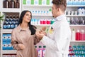 Man and woman pharmacist and client speaking at pharmacy Royalty Free Stock Photo