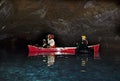 Man and Woman Photographing inside Lava Tube Lake Cave Royalty Free Stock Photo