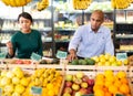 Man and woman picking ripe fruits and vegetables together at supermarket