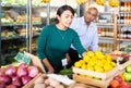 Man and woman picking ripe fruits and vegetables together at supermarket Royalty Free Stock Photo