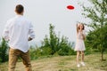 Man and woman playing frisbee in a park next to a river and forest ridge Royalty Free Stock Photo