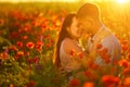 Man and woman in poppy field at sunset, romance Royalty Free Stock Photo