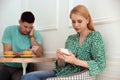 Man and woman preferring smartphones over speaking with each other during first date in cafe