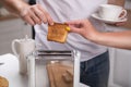 Man and woman preparing toast in the kitchen with a cup of aromatic coffee Royalty Free Stock Photo