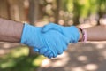 Man and woman in protective gloves shaking hands to say hello outdoors, closeup Royalty Free Stock Photo