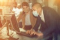 Man and woman in protective masks in panic looking for a solution on the computer in quest room Royalty Free Stock Photo