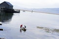 Man and woman pulling rubber boat on backwater of ocean with woo