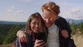 Man and woman reading good news on smartphone screen. Hikers using cellphone Royalty Free Stock Photo