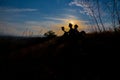 Man and woman reading in the park against sunset. Silhouette of couple reading book at sky sunset . warm tone and soft focus. Royalty Free Stock Photo