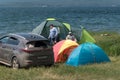 Man and woman relax in a tent camp on the shore of a Large lake in the summer season Royalty Free Stock Photo