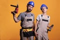 Man and woman renovators using drilling tools in studio Royalty Free Stock Photo