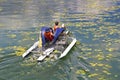 Man and woman ride with floating pedal bicycle boat