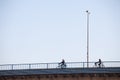 Man and woman riding bicycles in the city center of Belgrade, on the brankov most bridge, with the shape of their bikes at sunset.