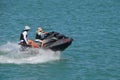 Man and a Woman riding tandem on a speeding jetski.