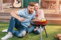 Man and woman roasting meat and vegetables on barbecue grill Royalty Free Stock Photo