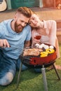 Man and woman roasting meat and vegetables on barbecue grill Royalty Free Stock Photo