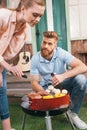 Man and woman roasting meat and vegetables Royalty Free Stock Photo