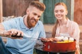 Man and woman roasting meat and vegetables Royalty Free Stock Photo