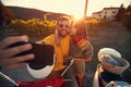 Man and woman on romantic journey on scooter at sunset and take selfie