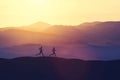 Man and woman running on a hill in the country