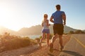 Man and woman running together on an empty road Royalty Free Stock Photo