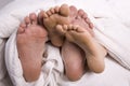 Man and woman's feet together under covers Royalty Free Stock Photo