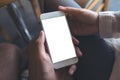 Man and woman`s hands holding and looking at white mobile phone with blank desktop screen together Royalty Free Stock Photo