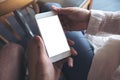 Man and woman`s hands holding and looking at white mobile phone with blank desktop screen together Royalty Free Stock Photo