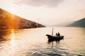 Man and woman are sailing in a boat with oars on the sea against the sunset sky Royalty Free Stock Photo