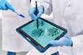 Man and woman scientist partners looking embryo image on touchpad at laboratory