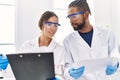 Man and woman scientist partners reading documents at laboratory