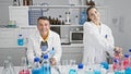 Man and woman scientists cheerfully working together in a high-tech laboratory