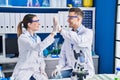 Man and woman scientists high five with hands raised up at laboratory Royalty Free Stock Photo