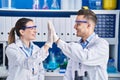 Man and woman scientists high five with hands raised up at laboratory Royalty Free Stock Photo