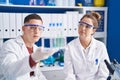 Man and woman scientists holding test tubes at laboratory