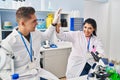 Man and woman scientists partners high five with hands raised up at laboratory Royalty Free Stock Photo