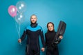 Man and woman scuba diver with pink ballon on blue background Royalty Free Stock Photo