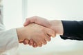 Shaking hands, concept for teamwork: Close up of man and woman shaking hands in the office Royalty Free Stock Photo