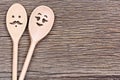 Man with woman shape of wooden spoons on table