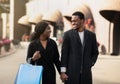 Man and woman with shopping bags talking and smiling, walking down the street after Black Friday and season sale Royalty Free Stock Photo