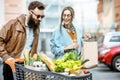 Man and woman with shopping cart full of food outdooors Royalty Free Stock Photo