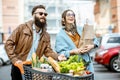 Man and woman with shopping cart full of food outdooors Royalty Free Stock Photo