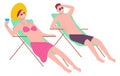 Man and woman sit on beach deckchairs. Couple resting on resort