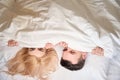 Man and woman sit comfortably under blanket ona large bed Royalty Free Stock Photo