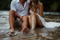 man and a woman sit peacefully in the water of a tranquil pond, their bodies gently touching as they connect with nature Royalty Free Stock Photo