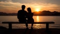 A Man and a Woman Sitting on a Bench Watching the Sunset Royalty Free Stock Photo