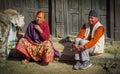 Man and woman sitting on the curb watching people go by, Bhaktapur, Nepal Royalty Free Stock Photo